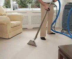 Carpet cleaning professional removing dirt and stains with a hot-water extraction tool in a home, Cedar Rapids, IA.